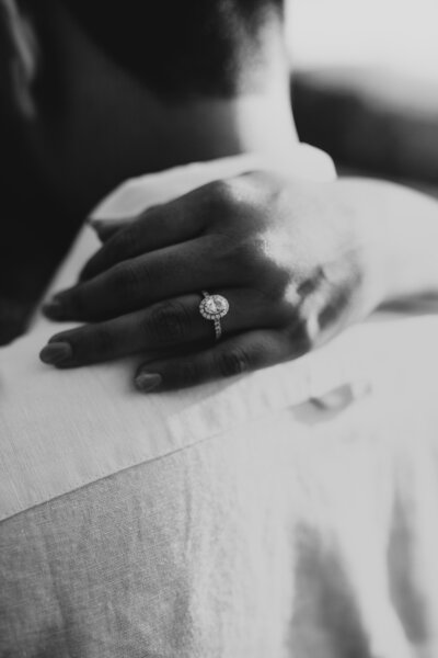 black and white photo of woman's hand wearing a wedding ring