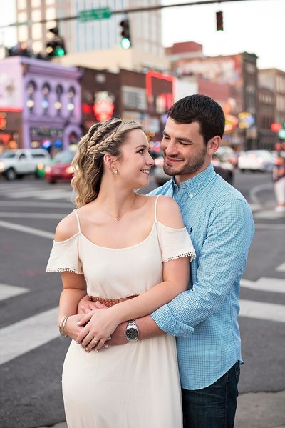 Engagement picture of couple with iconic Tootsies on Broadway in the background