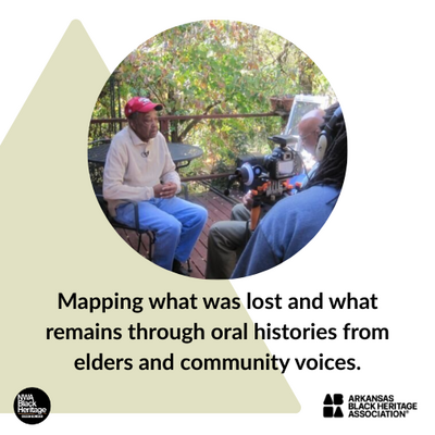 An elder shares stories in a recorded interview, seated outdoors, surrounded by community—preserving memory through spoken word