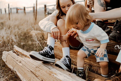 Large family with a toddler boy play on a pile of wood planks