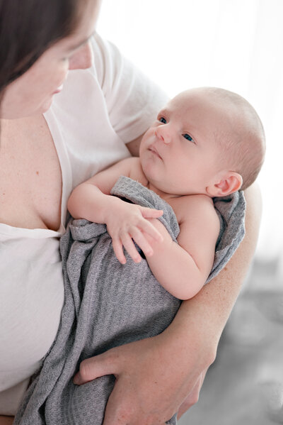 A mother and newborn baby looking at each other during their newborn photoshoot in Huntsville Alabama