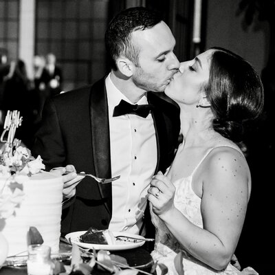 bride and groom kissing after cutting their wedding cake at lilah events in philadelphia