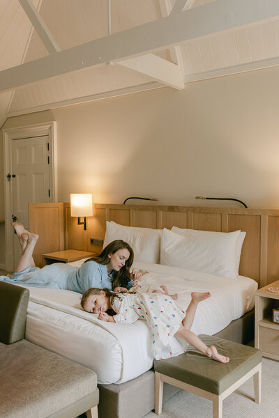 A mother, daughter and baby hanging on the bed. 