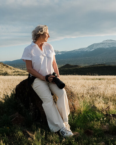 photographer tommie guy in a golden field with her camera