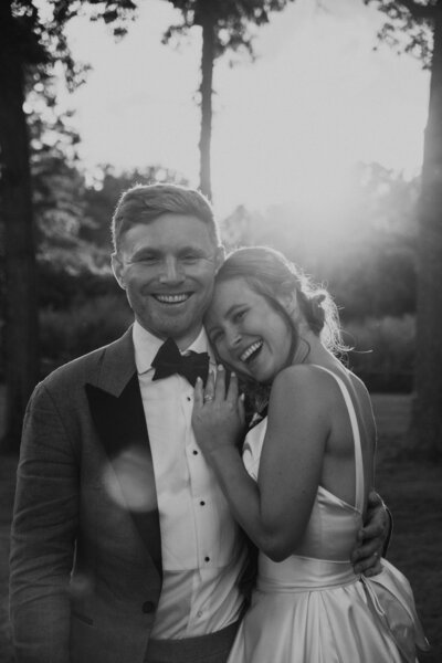 Black and white image of bride resting her head on groom's shoulder