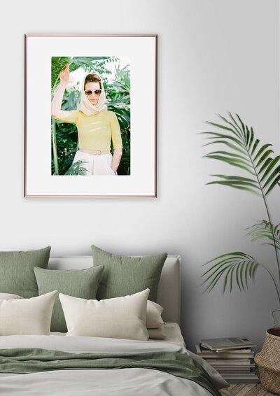 calm green bedroom design with framed tropical fashion portrait