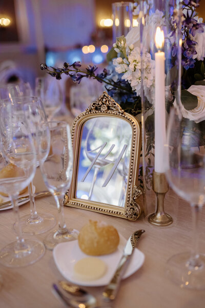 Gold-framed table number sign with photo displayed on elegant reception table