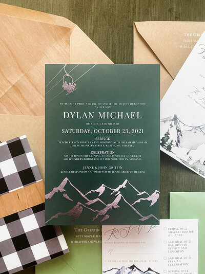 Green Bar Mitzvah invitation suite with ski theme and brown envelopes.