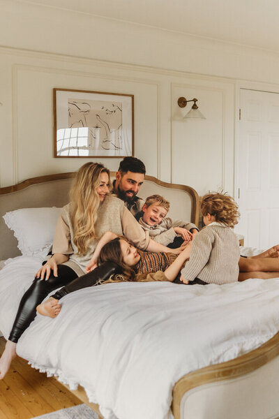 family sitting on the bed at home