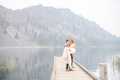 Bride and groom by lake and mountains