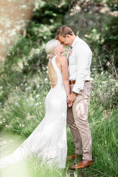 A bride and groom kissing with the brides veil blowing in the wind.