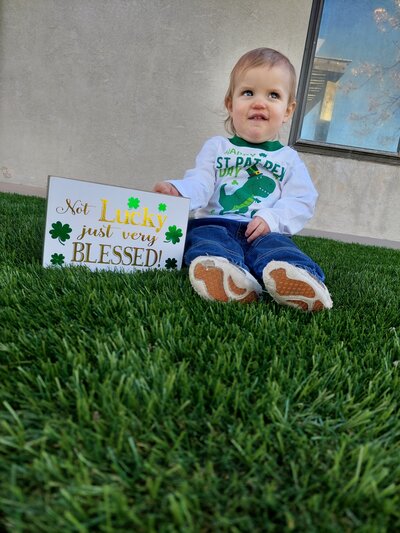 Young Girl with St Patricks Day Sign Smiling CPC Albuquerque Childcare