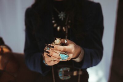 Turquoise Rings on hands while holding a lizard