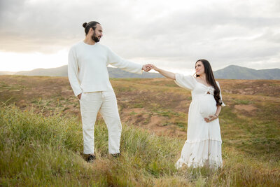 Photo of Couple holding hands looking at each other | California Maternity Session
