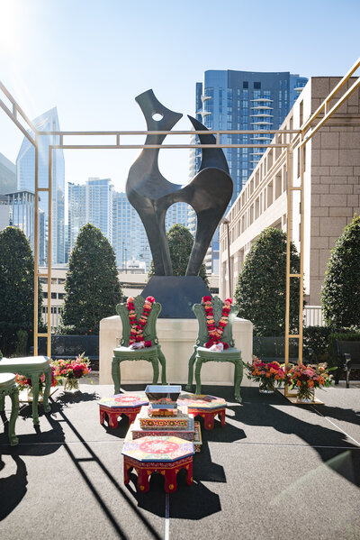 Elegant Indian wedding mandap setup with floral garlands, ceremonial chairs, and sacred fire altar at the Grand Bohemian Hotel Charlotte, photographed by a professional Indian wedding photographer in Charlotte.