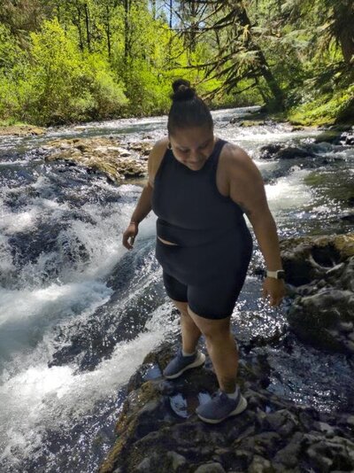 Ashley standing in a creek in Oregon.