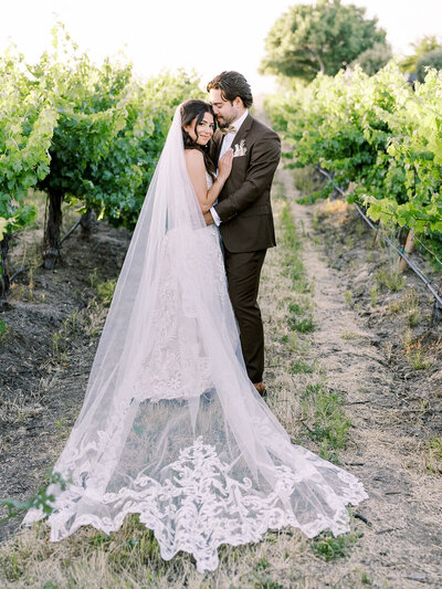Bride walking through stone arch at Sunstone Winery in Santa Ynez