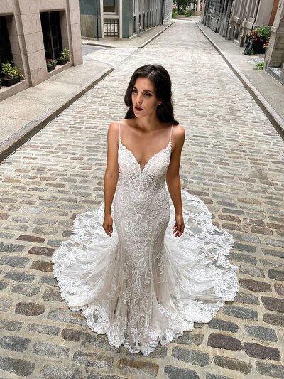 Looking to show off your shoulders and collarbones? This sophisticated crepe sheath bridal dress features an off-the-shoulder neckline and lacy straps to help you do just that.