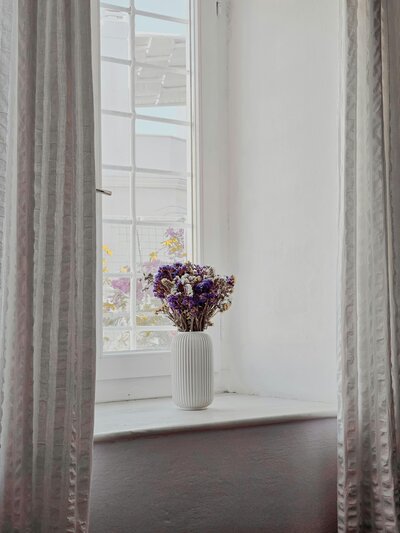 Vase of flowers in bright window light | Rooted Within creating grounded family spaces