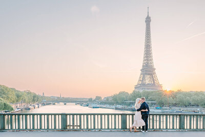 Couple embracing during Paris photoshoot with Eiffel tower and sunset in the background