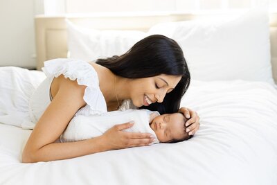 newborn and mom on a white bed