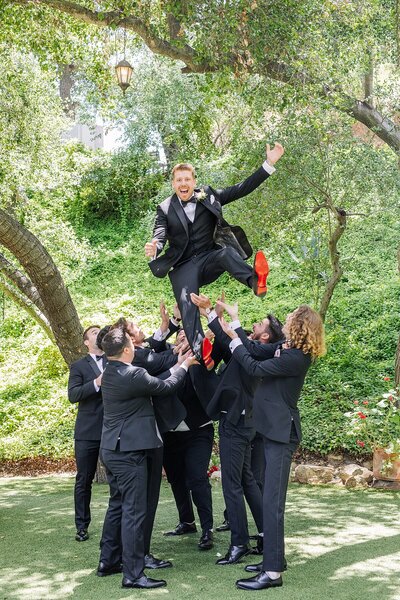 Groomsmen throwing groom at Los Willows Wedding Venue in Fallbrook, California.