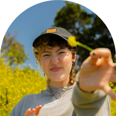 young woman holds flower and smiles