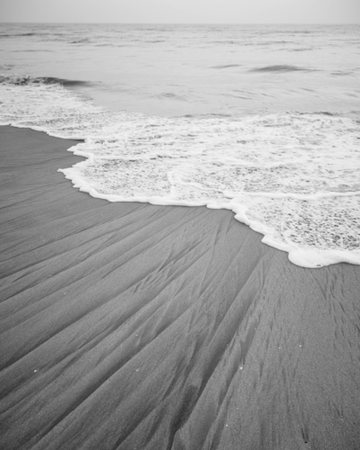 Black and white image of beach shoreline