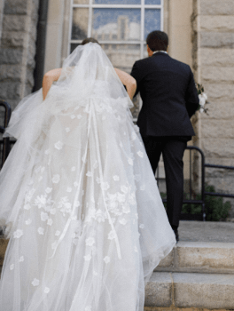 A bride and groom walking up the steps