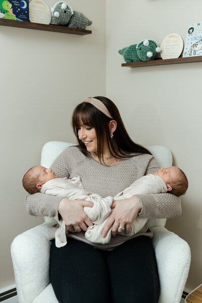 mom holding twin newborn in nursery in pottstown pa