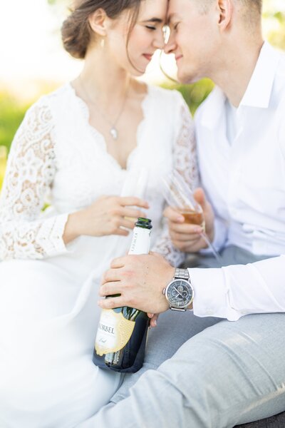 Bride and groom sharing champagne for engagement session.