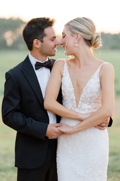 Magnolia Hill Farm wedding with groom wrapping his arms around his bride and touching his nose to her romantically