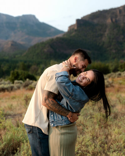 Montana couple laughing during a sunset photo session in the mountains