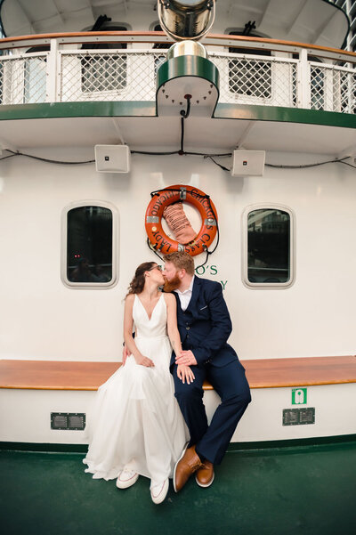 Bride and groom kiss on the front of the boat on Chicago's First Lady Cruise.