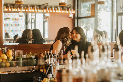 A person leaning over and kissing their partner on the cheek 
