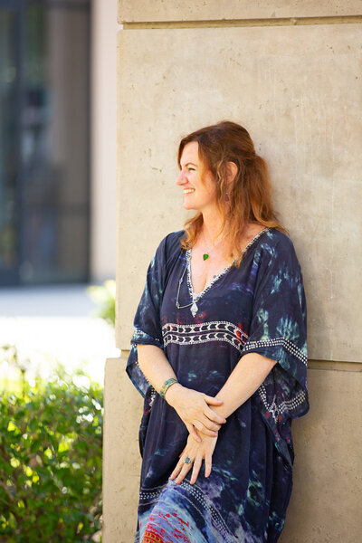 woman leaning on wall smiling