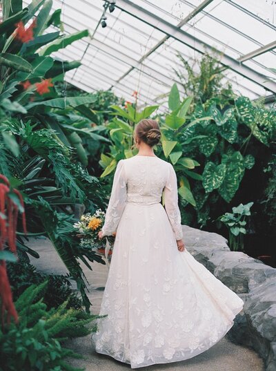 Back of the brides wedding dress in conservatory