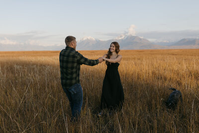 A couple playing in a field of tall grass.