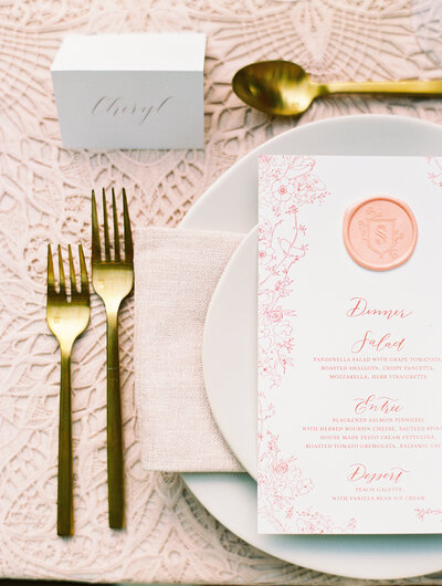 Dinner menu with peach colored digital print and oversized wax seal with handdrawn floral line art