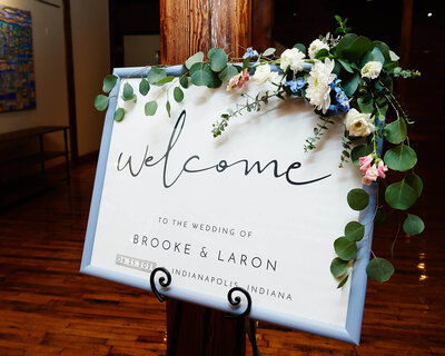 welcome sign with blue and pink flowers