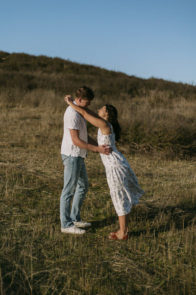 Elizabeth leaning into her husband David with her arms over his shoulders. Click for more photos from their couples session