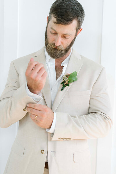 Groom relaxing in rustic groom’s lounge at barn wedding venue Tennessee