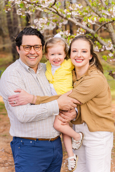 parents and toddler hugging in a Atlanta Brookhaven park GA by Laure Photography