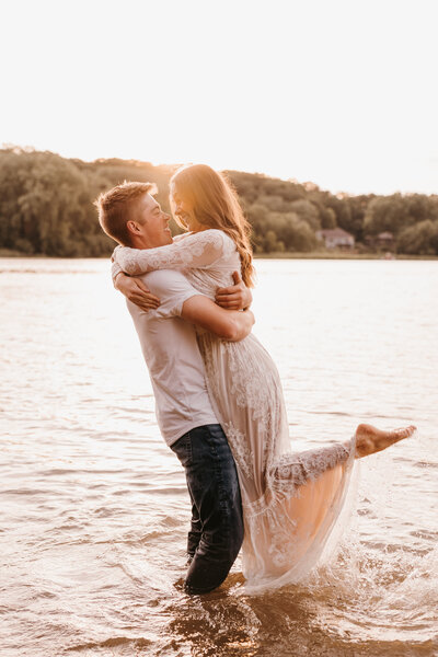 Couple splashing in lake for engagement photos