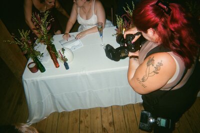 A photographer taking a picture at a wedding reception.