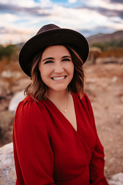 Stephanie testimonial photo. She is wearing a brown hat and red dress.