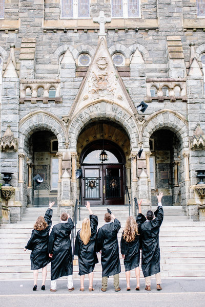 Group of Georgetown University seniors throwing caps during graduation portrait session