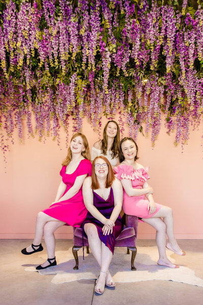 4 beautiful girls smiling in dresses posing at styled and staged st. louis