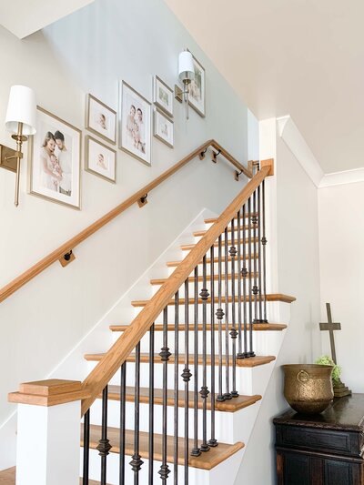 Gallery wall of newborn and baby photos in staircase.