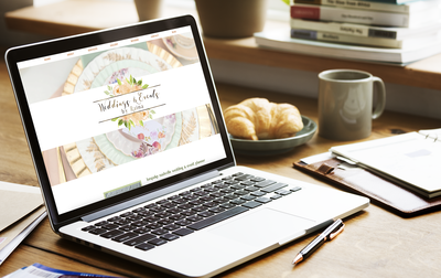 Wedding planner website home screen on laptop with breakfast and coffee beside it